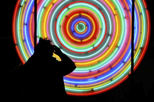 Photographer standing in front of neon lights circles, night photography