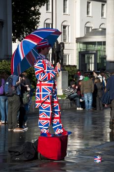 Human statue dressed in the Union Jack flag, London, UK