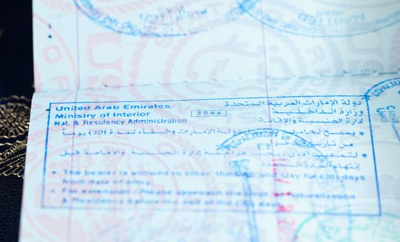 Macro image of visa and immigration stamps in US passport for Dubai or Abu Dhabi in the UAE