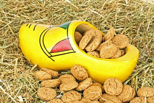 Traditional dutch wooden clog with  gingernuts in straw for 5 december santa claus feast in the Netherlands