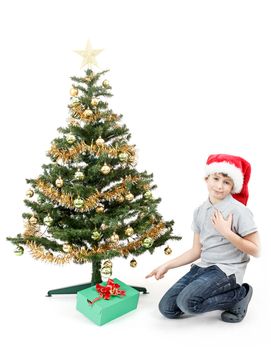 surprised boy in santa hat with christmas present on white background