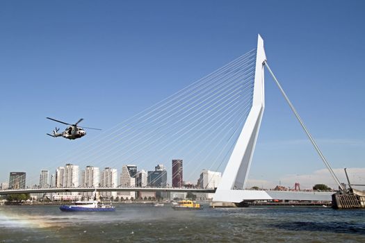 ROTTERDAM, NETHERLANDS - SEPTEMBER 09: Army helicopter is flying in front of the erasmus bridge during the world harbor days on 9 september 2012 Rotterdam the Netherlands