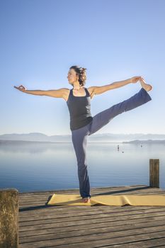 An image of a pretty woman doing yoga at the lake