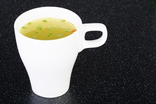 Broth in cup on table