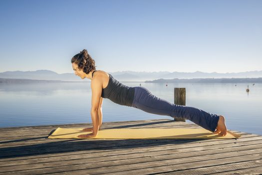 An image of a pretty woman doing yoga at the lake