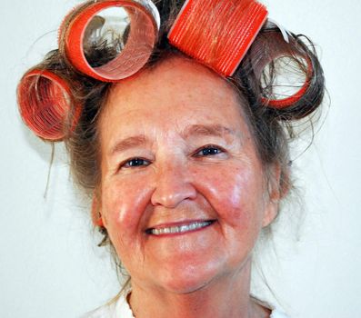 Mature female with big curlers in her hair.