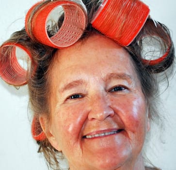 Mature female with big curlers in her hair.