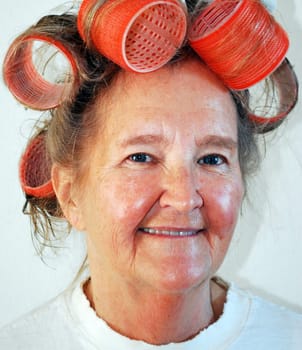 Mature female with big curlers in her hair.