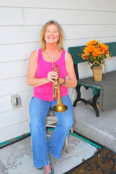 Mature female jazz trumpet player with her instrument.