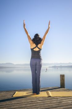 An image of a pretty woman doing yoga at the lake