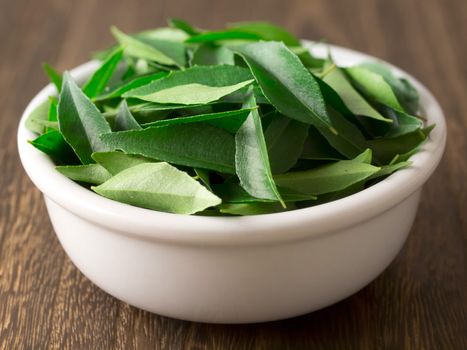 close up of a bowl of fresh indian curry leaves