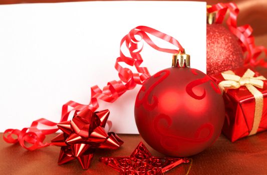 Red Christmas decorations and white card with copy space. 