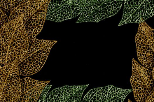Green and golden leaves forming an abstract frame over black background.