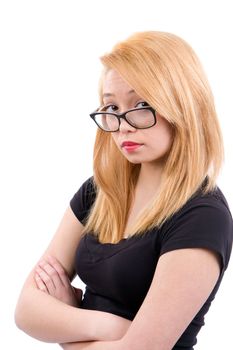 Female teenager with crossed arms has a questioning attitude as she looks over the top of her eyeglasses.