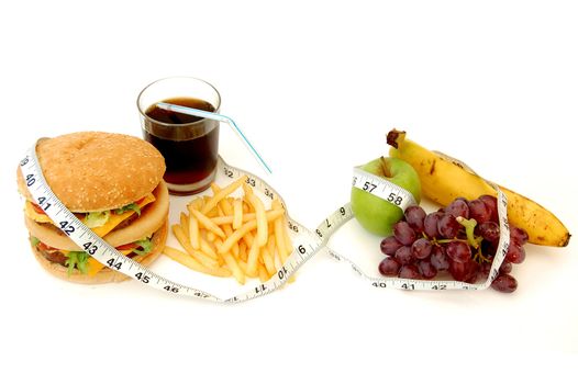 Tape measure wrapped around unhealthy and healthy food options