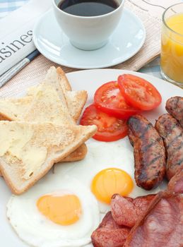 Business and financial newspapers next to a plate with a cooked breakfast 