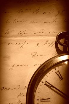 Retro pocket watch on an old letter in sepia