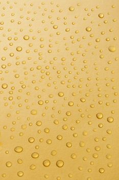 Closeup image of water droplets on a gold background