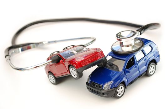 Stethoscope around toy cars in a crash position