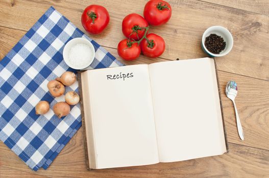 Open blank recipe book surrounded with ingredients 