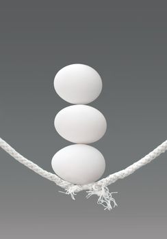 Stack of eggs on top of a breaking tightrope 