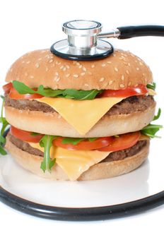 Stethoscope around an unhealthy double cheeseburger  
