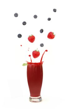Berries splashing into a blended smoothie
