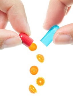 Conceptual image of oranges pouring out of an opened pill 