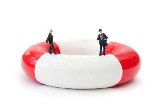 Miniature businessman on a life ring
