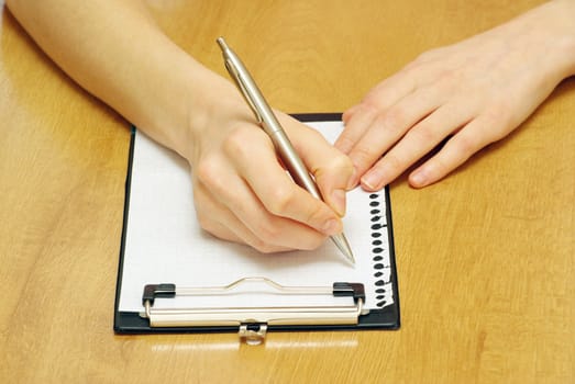 pen in hand isolated on wood background