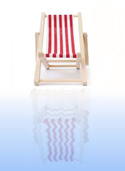 Red deckchair reflecting into water