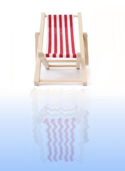 Red deckchair reflecting into water
