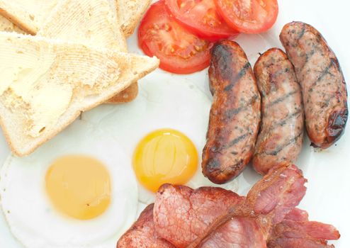 Closeup of a traditional english breakfast fry up with sausages, eggs and bacon