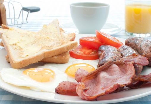 Traditional english breakfast fry up with sausages, eggs and bacon