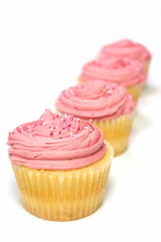 Delicious pink cupcakes on a white background