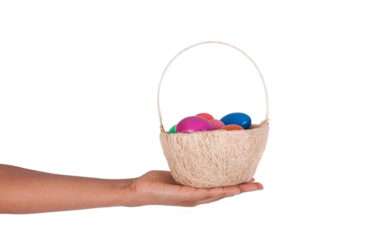 Hand holding colorful Easter eggs in the basket