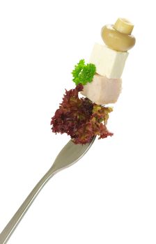 Fresh vegetables on a fork isolated on white background