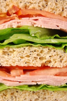 Closeup of a large healthy ham sandwich with tomatoes and lettuce