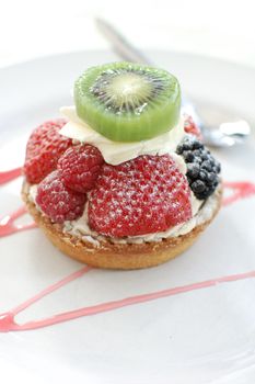 Cream filled tart with berries and kiwi fruit