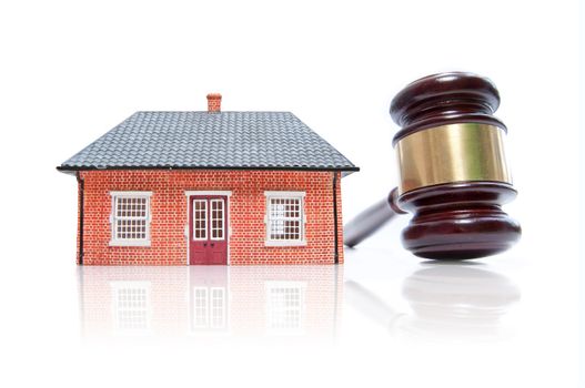 Model house and gavel over a white background