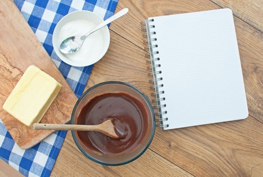 Blank recipe book surrounded with ingredients including hot chocolate