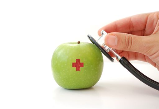 Stethoscope held over an apple with a red cross 