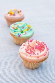 Three delicious cupcakes with sprinkles