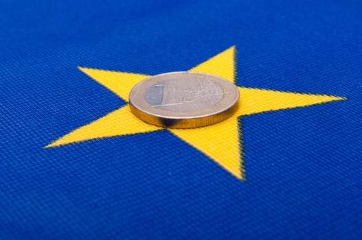 One Euro Coin on Blue Flag of European Union
