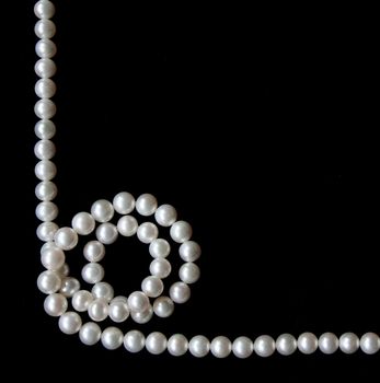 White pearls on the black velvet background 