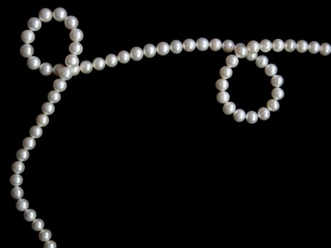 White pearls on the black velvet background 