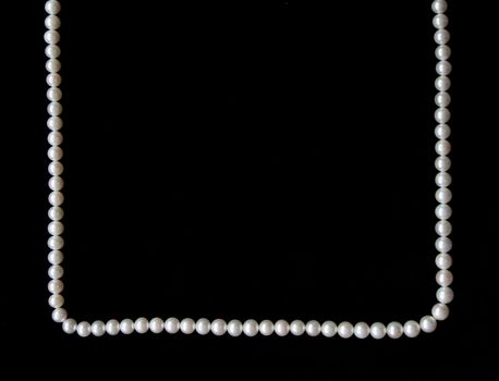 White pearls on the black velvet background 