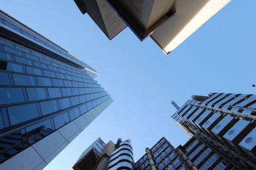 Tall modern office buildings against a blue sky