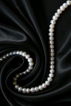 White pearls on the black silk can use as background 