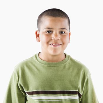 Young latino adolescent boy standing smiling at viewer.